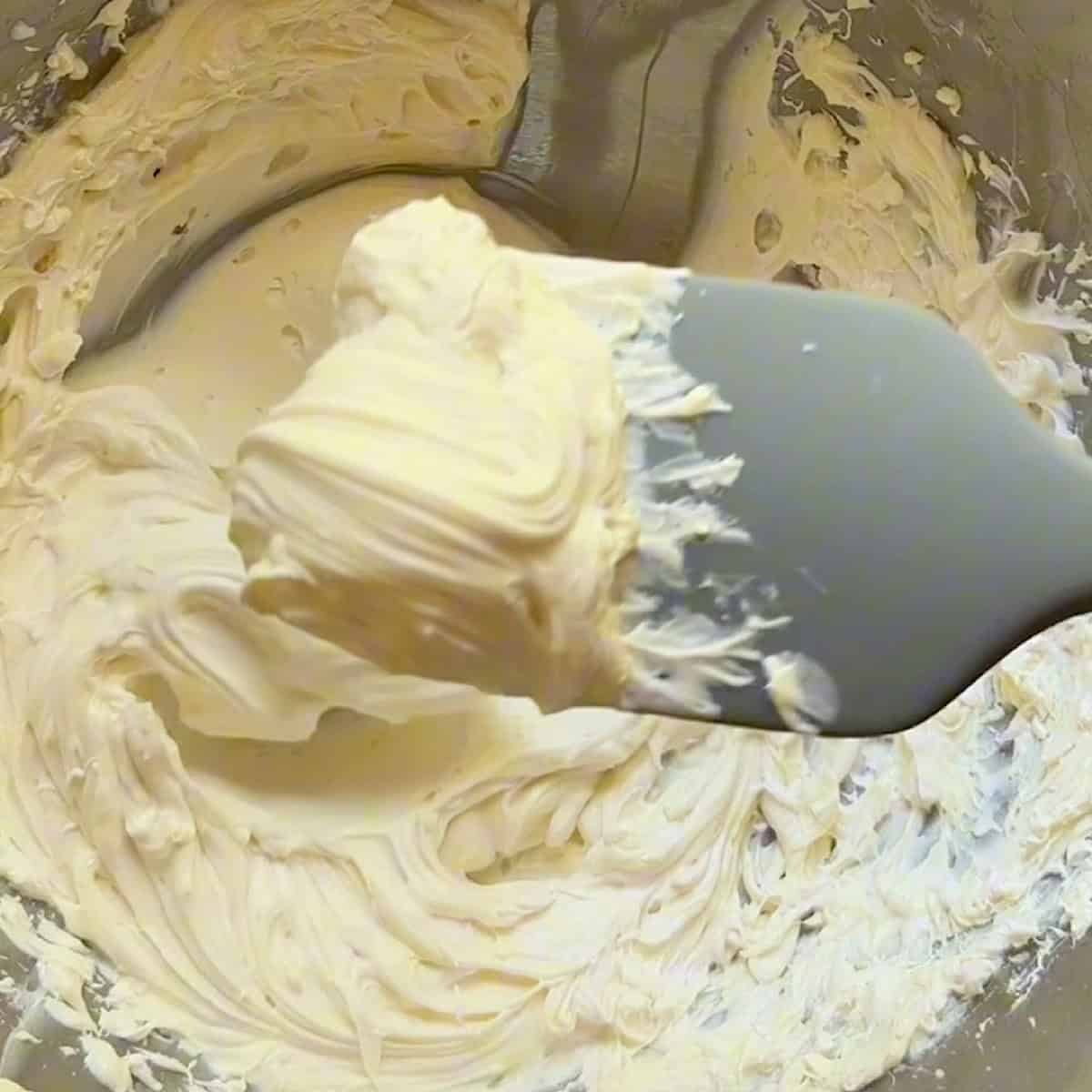 Holding a spatula full of fluffy cream cheese filling.